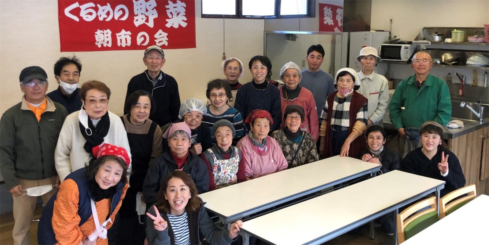 「くるめの野菜 朝市の会」の幕の前に集まった参加者のみなさん