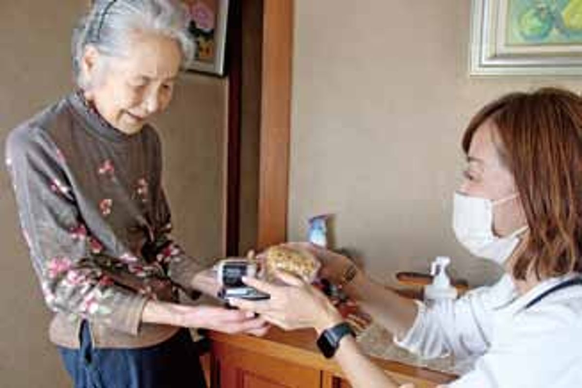 玄関先でお弁当を手渡しながら、言葉を交わしている様子
